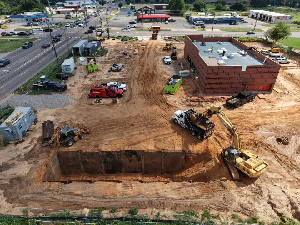 Excavators opening the tank pit beside the store building