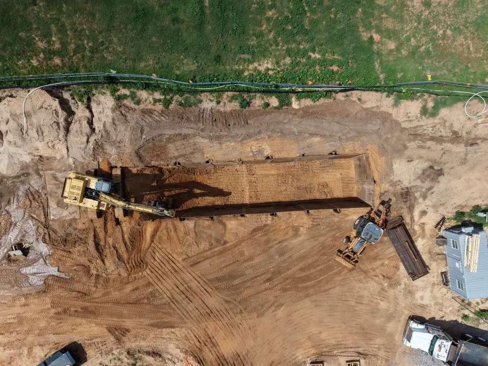 Excavator digging the tank pit along the property edge