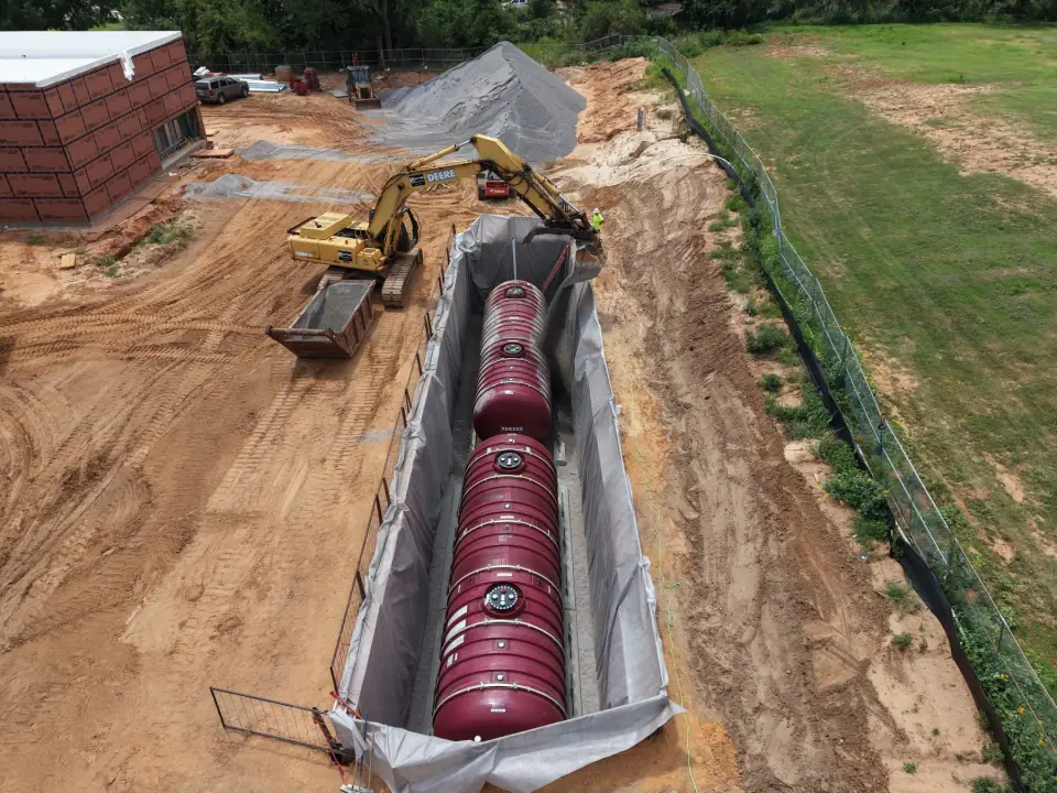 Tanks set end to end in the excavation as backfill begins