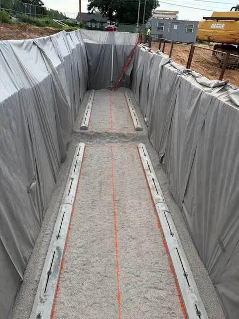 Looking down the length of the lined tank excavation