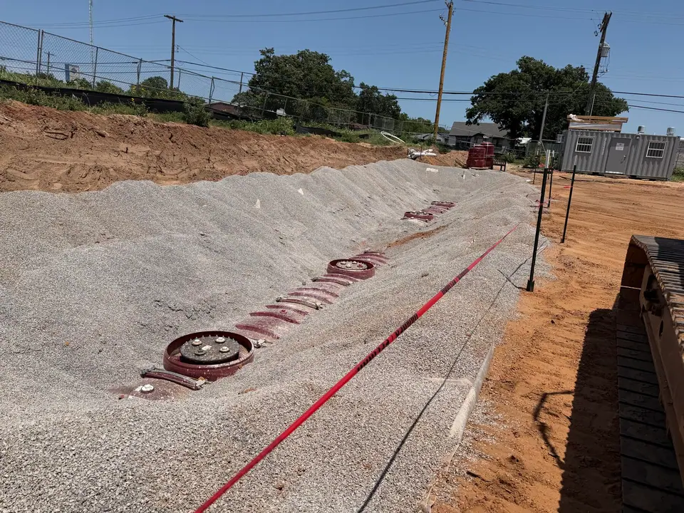 Tanks backfilled with pea gravel, manways exposed