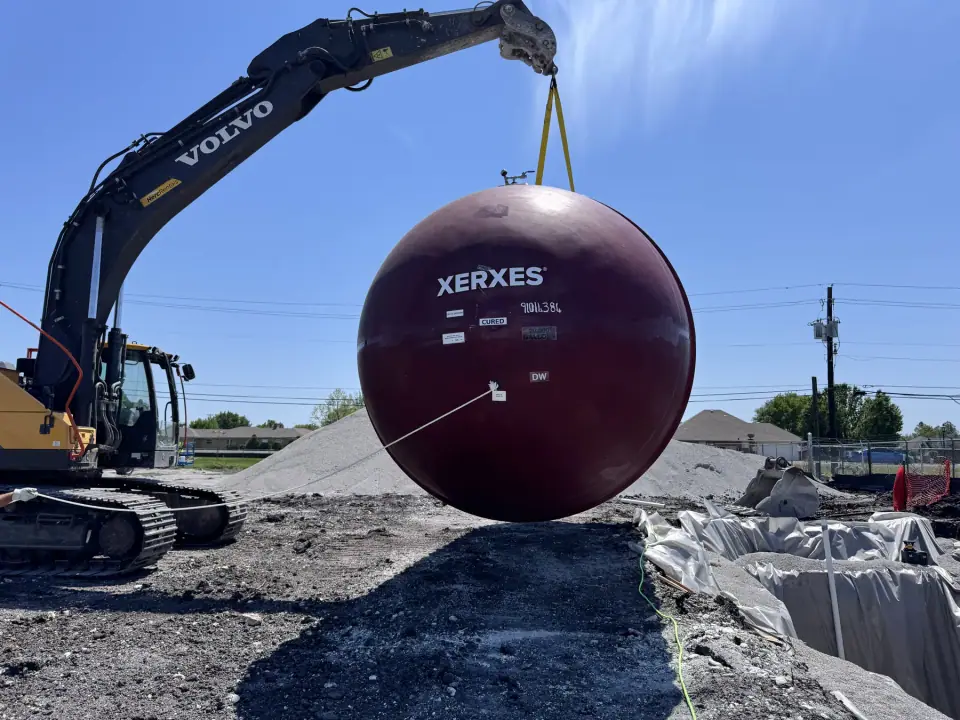 End view of a tank lifted over the excavation
