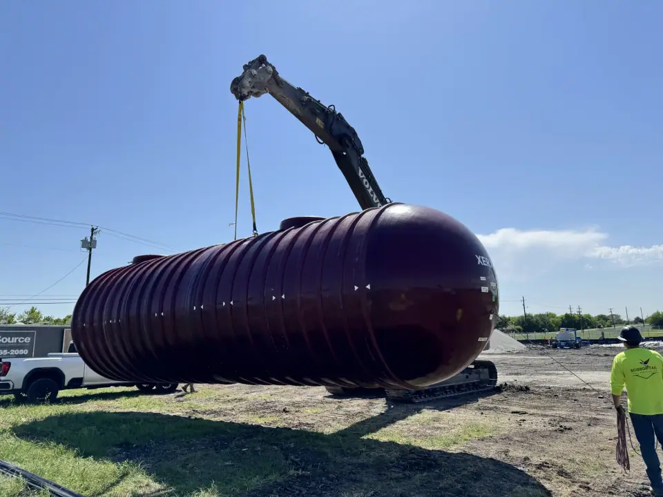 Tank carried across the site by excavator