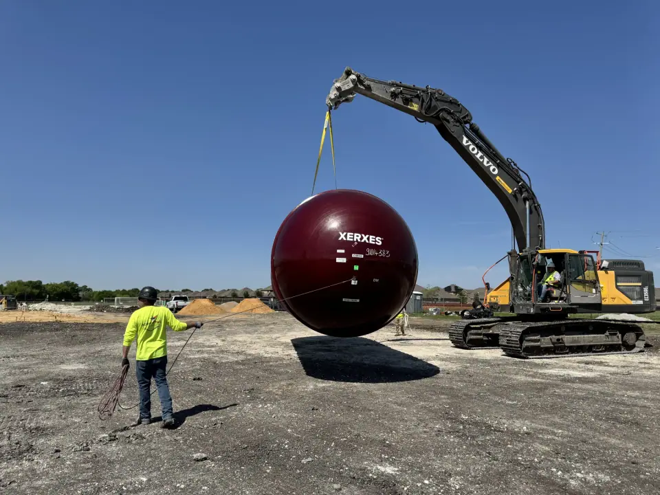 Crew walking a tank across the site with taglines