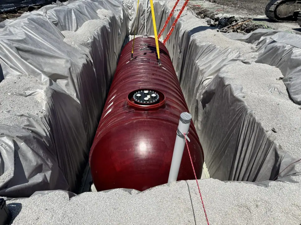 Tank set in the excavation with manway and riser