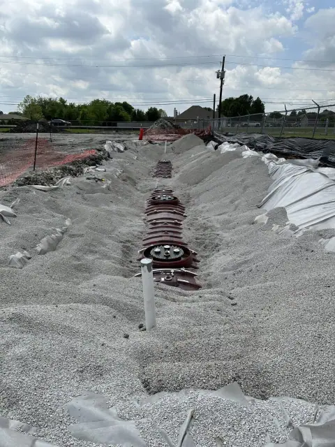 Backfilled tank pit with manway and risers