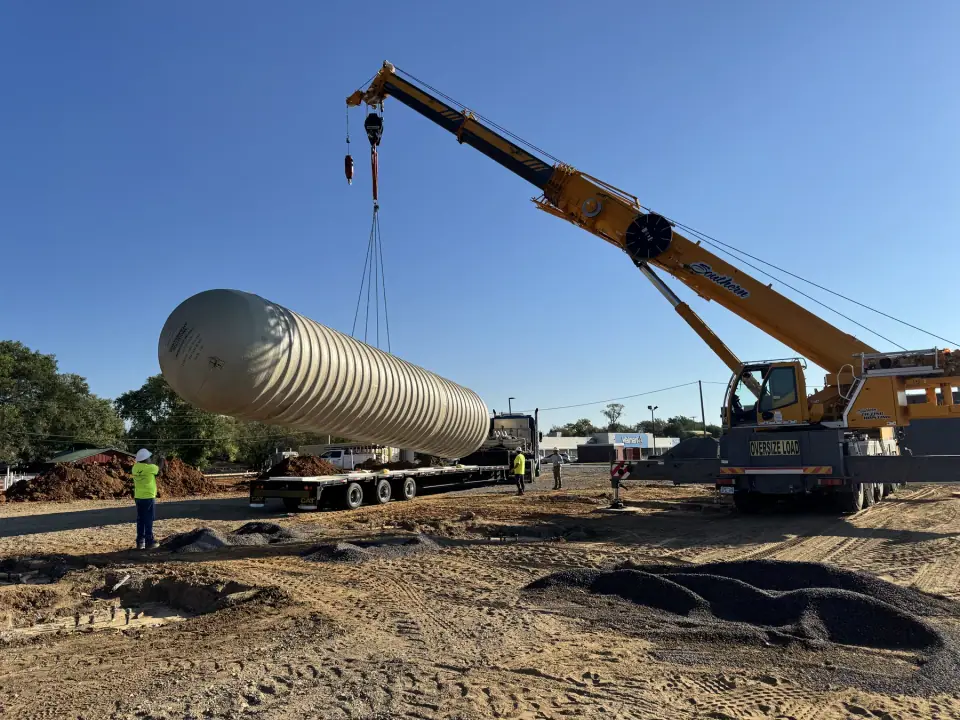 Tank raised by crane with the crew on taglines
