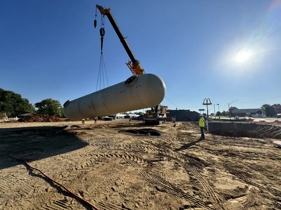 Crane carrying a tank toward the pit