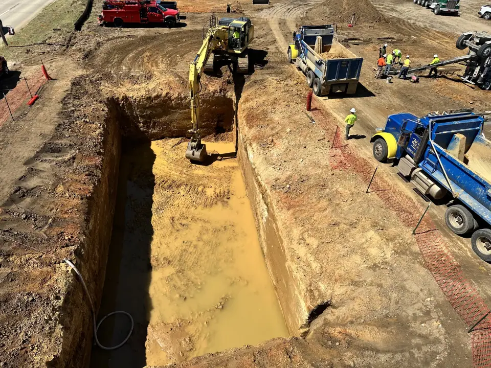 Deep tank excavation with trucks hauling spoils