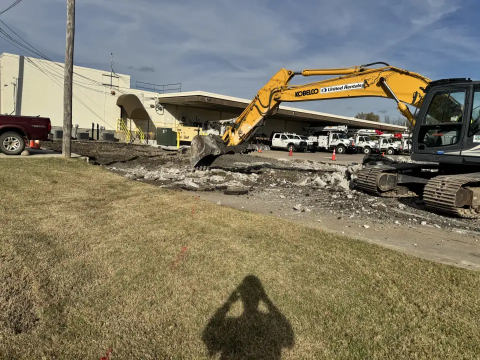 Excavator breaking out the old concrete ahead of the tank removal