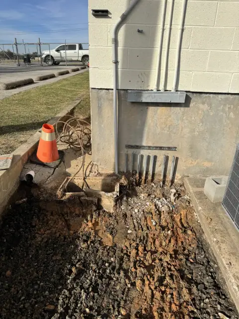 Underground electrical conduit stubbed up along the building