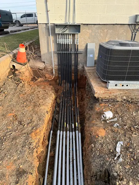 Electrical conduit trench along the building
