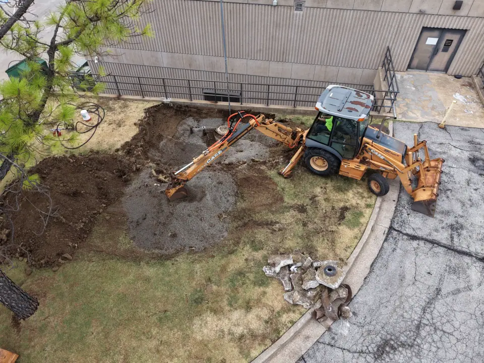 Backhoe removing soil over the old tank